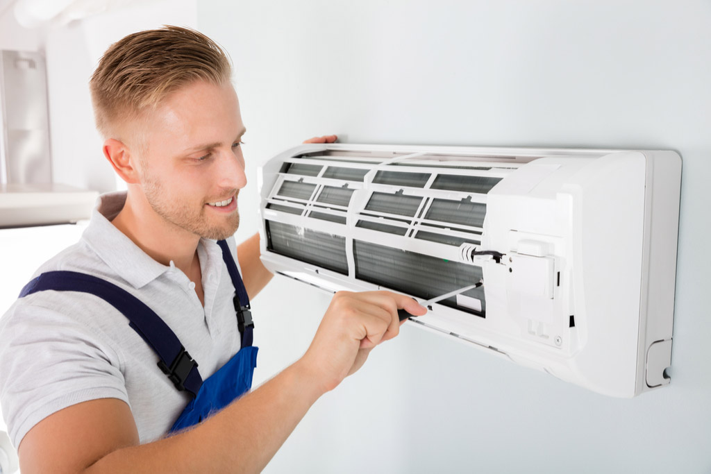 HVAC technician cleaning and repairing a ductless mini split AC in Maricopa, AZ