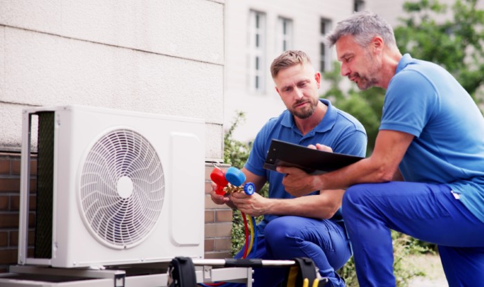 HVAC technicians reviewing an outdoor air conditioning unit in Maricopa, AZ