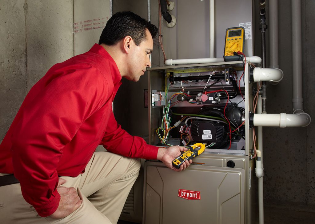 Heating and air conditioning technician servicing an indoor furnace in Maricopa, AZ