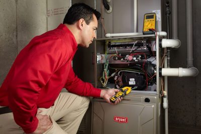 Heating and air conditioning technician servicing an indoor furnace in Maricopa, AZ